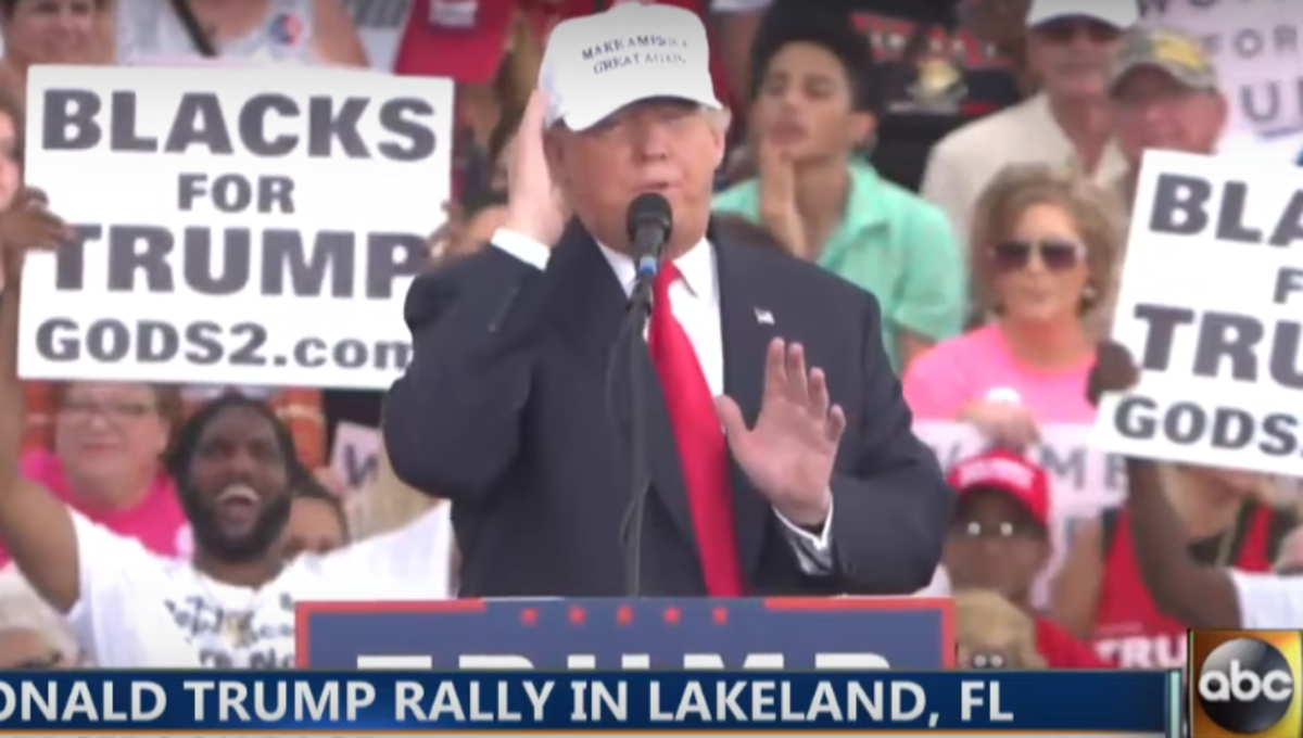 Donald Trump wearing a white make america great again hat.
