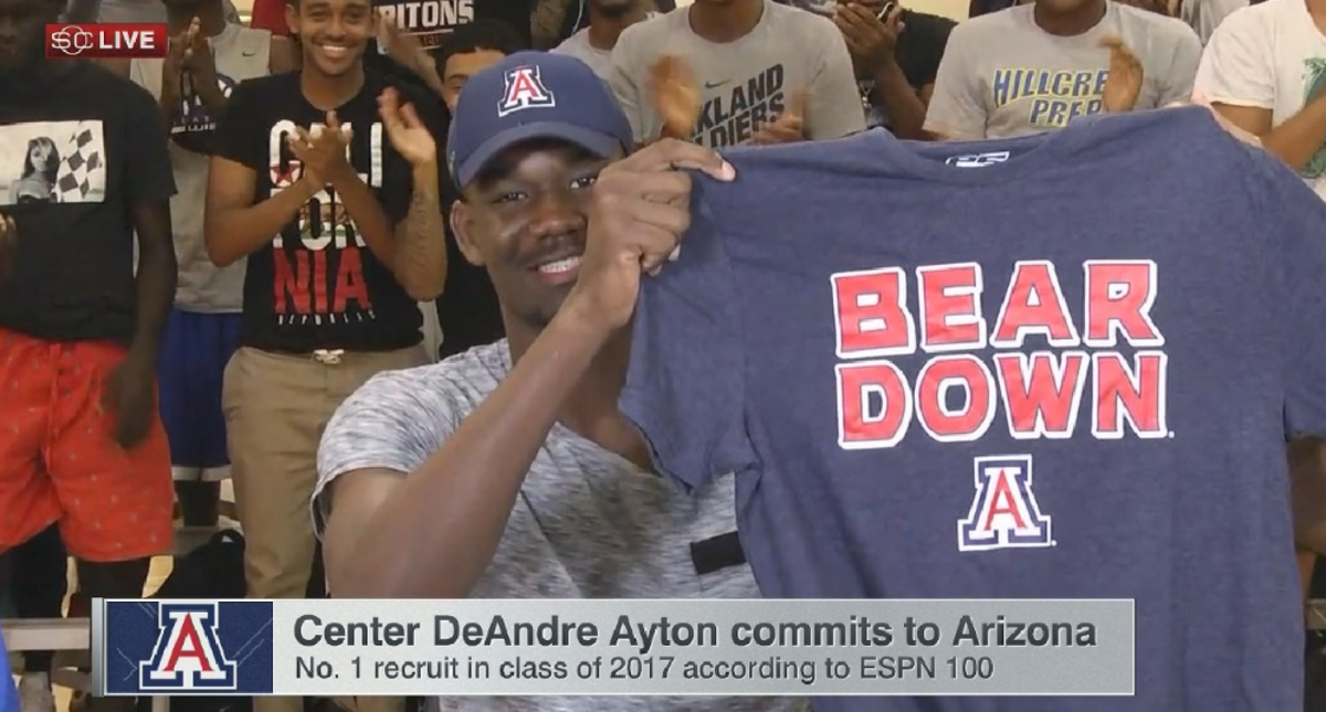 DeAndre Ayton holding up a t-shirt as he commits to play for Arizona