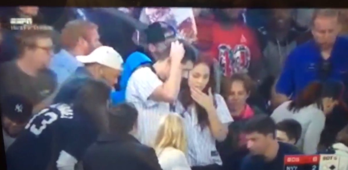 Yankees fan stares helplessly after losing an engagement ring.