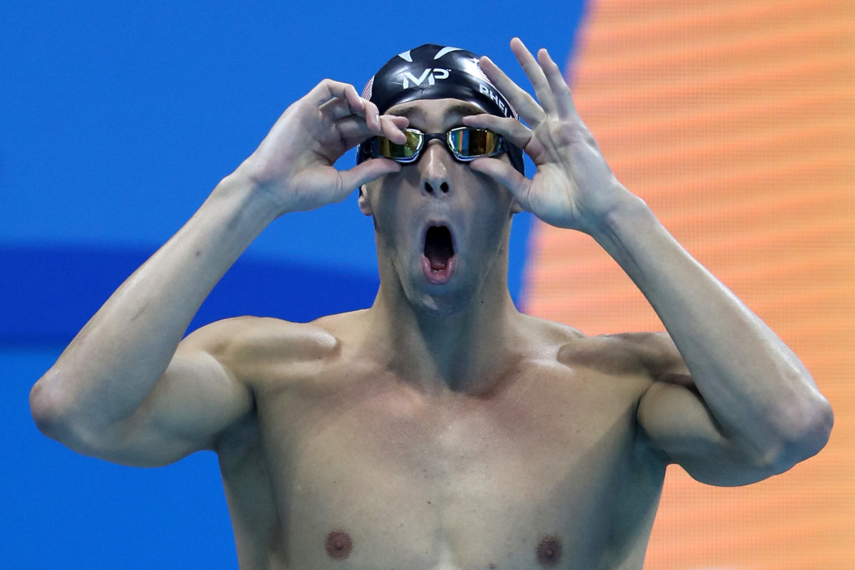 Michael Phelps adjusting his goggles.
