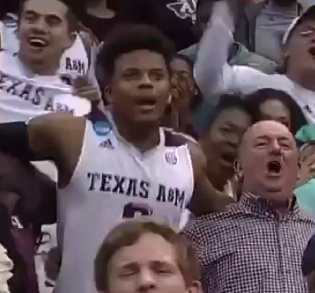 Texas A&M player in the crowd singing fight song.