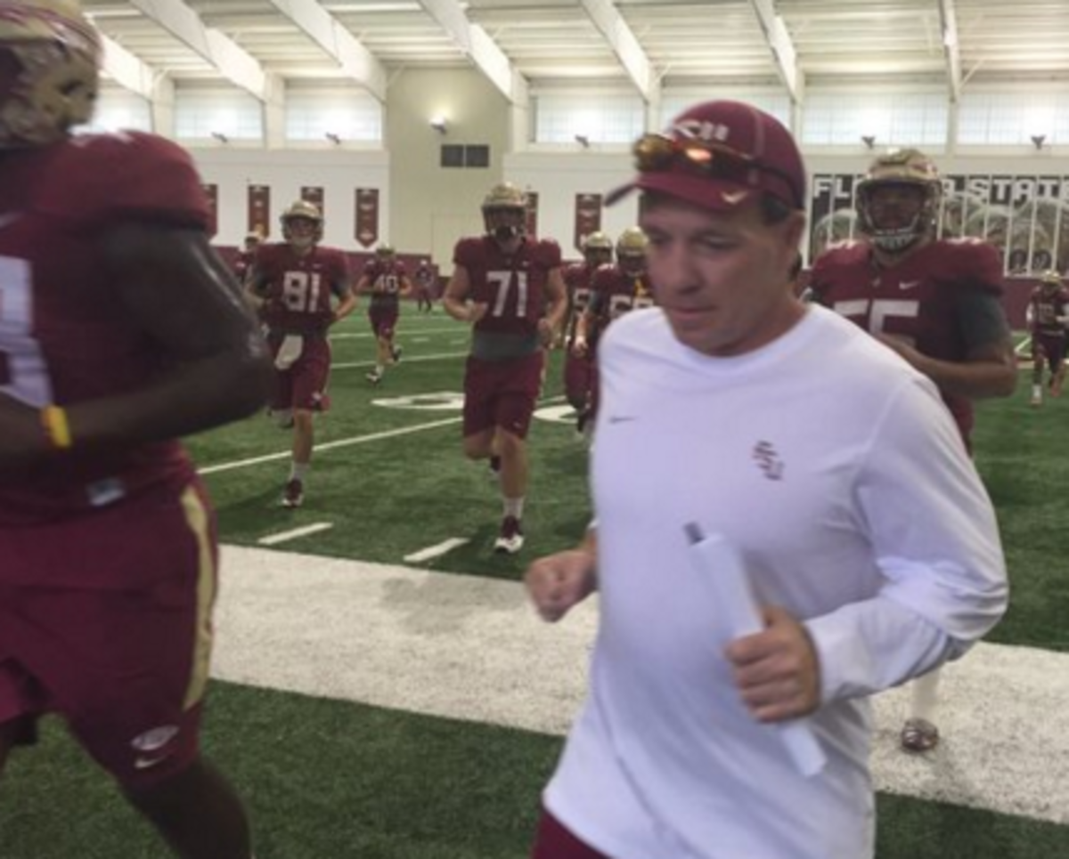 Jimbo Fisher leads the Florida State players off of the football field.