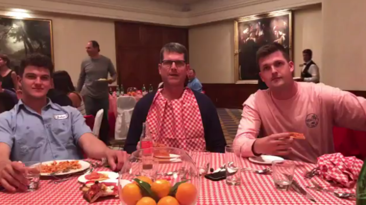 Jim Harbaugh enjoys pizza in Rome with players.