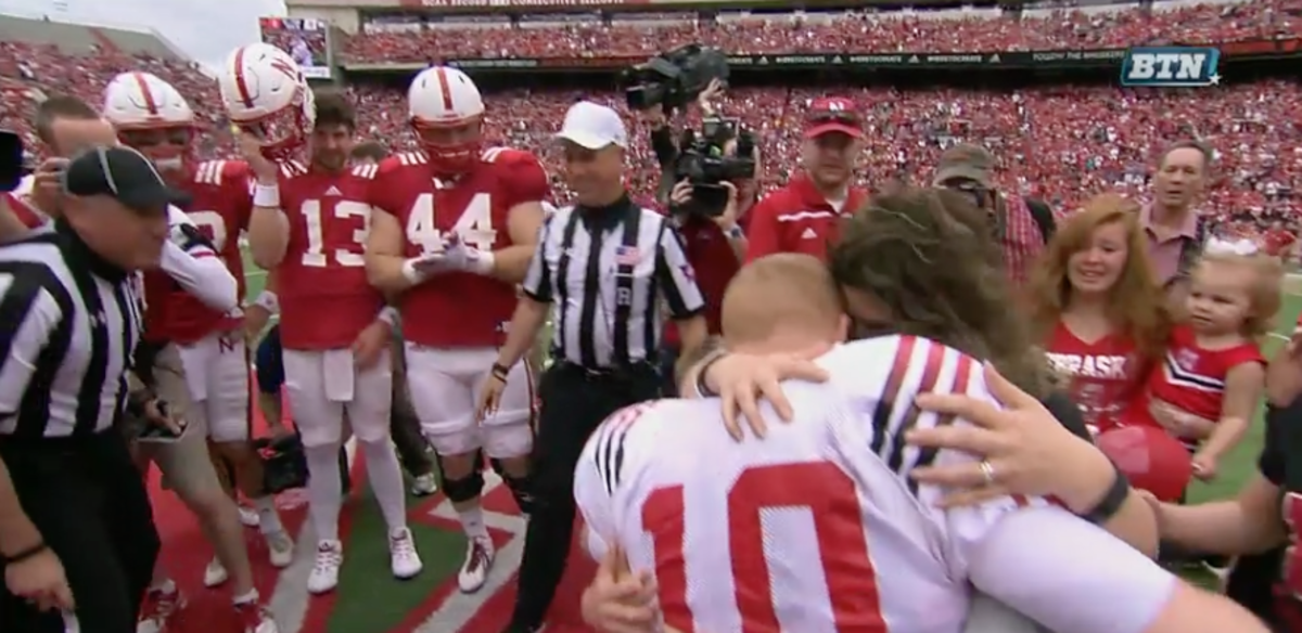 Army Sergeant embraces family as he surprises them at the Nebraska football coin toss.