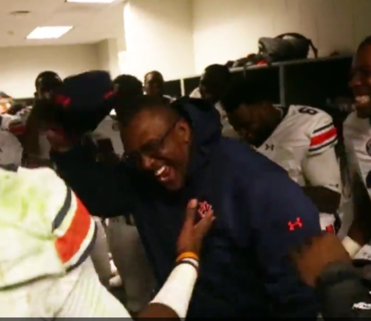 Auburn players and coaches are excited in the locker room after beating Texas A&M.