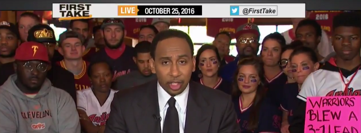 Stephen A Smith standing in front of fans.