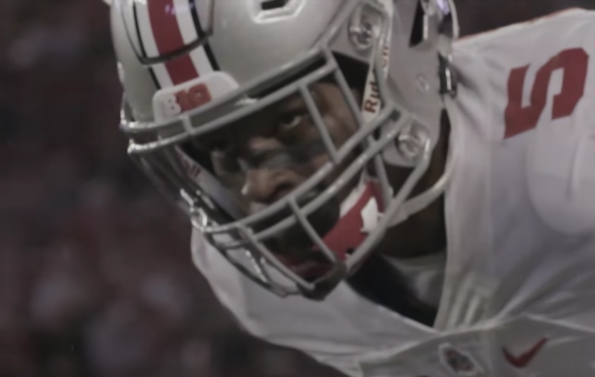 An Ohio State player wearing his helmet on the field.
