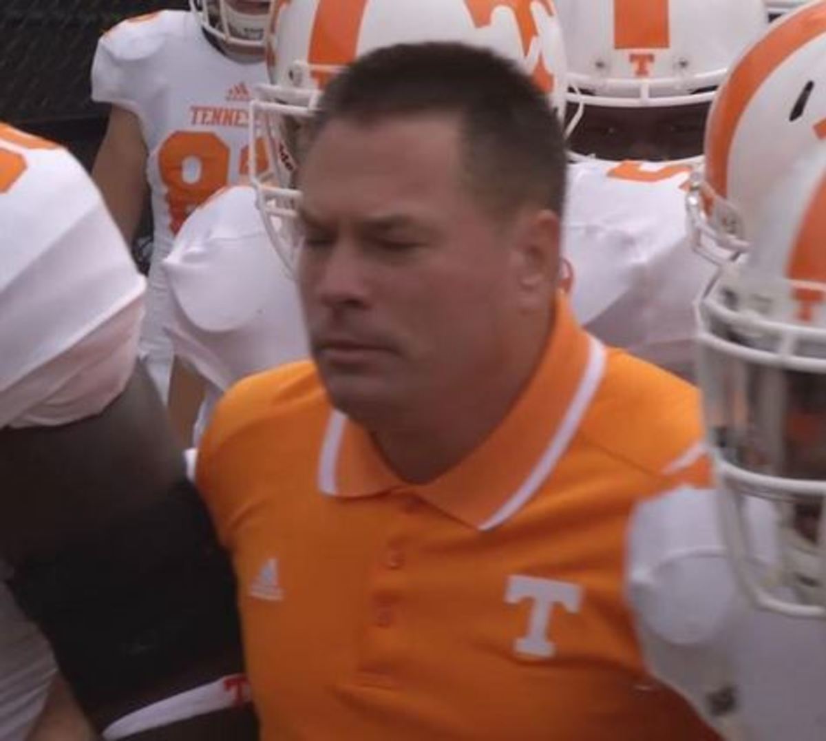 Butch Jones surrounded by his players.
