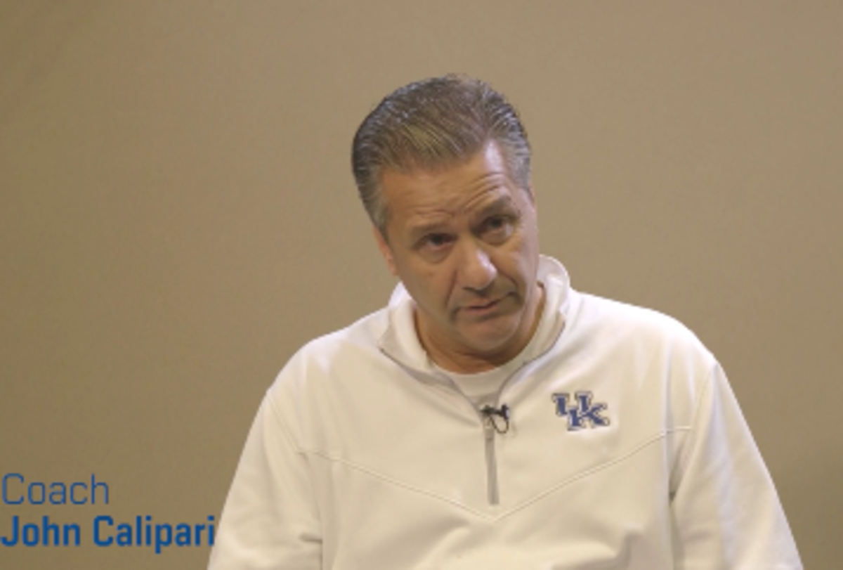 John Calipari sits in a Kentucky sweatshirt.