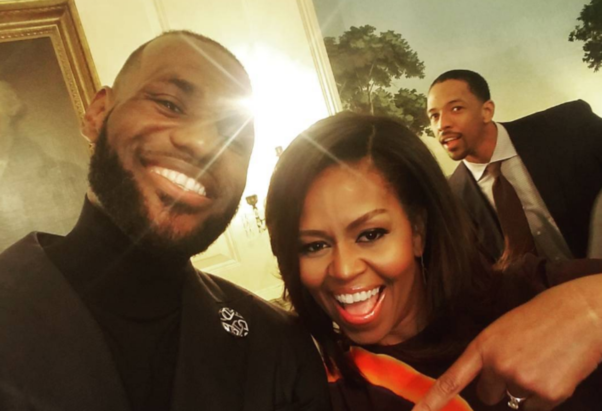 LeBron James takes a photo with Michelle Obama.