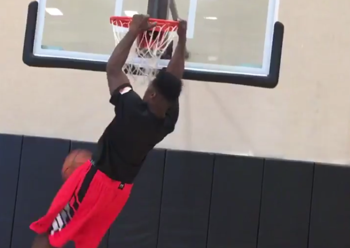 Myles Jack dunks a basketball and hangs on the rim