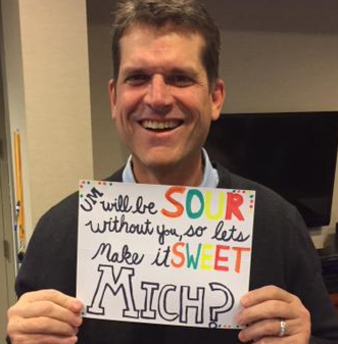 Jim Harbaugh with a weird sign.