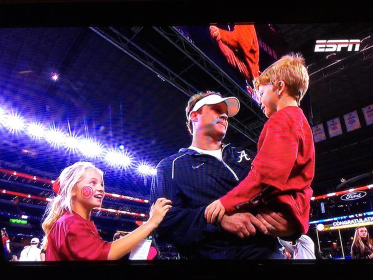 Lane Kiffin holding his son after Alabama wins national championship.