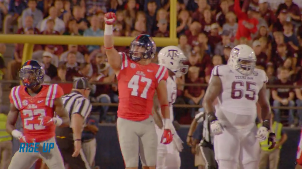 Ole Miss player raising his hand during a game.