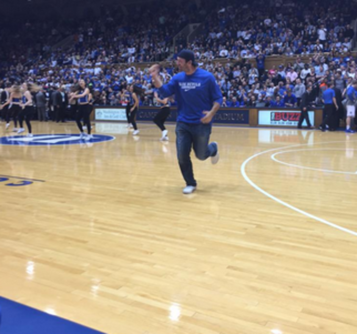 Tony Romo runs across the basketball court.