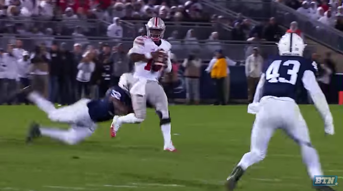 J.T. Barrett getting tackled by a Penn State player.