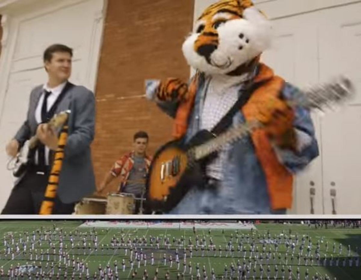 The Auburn Tiger plays the guitar during the halftime show.