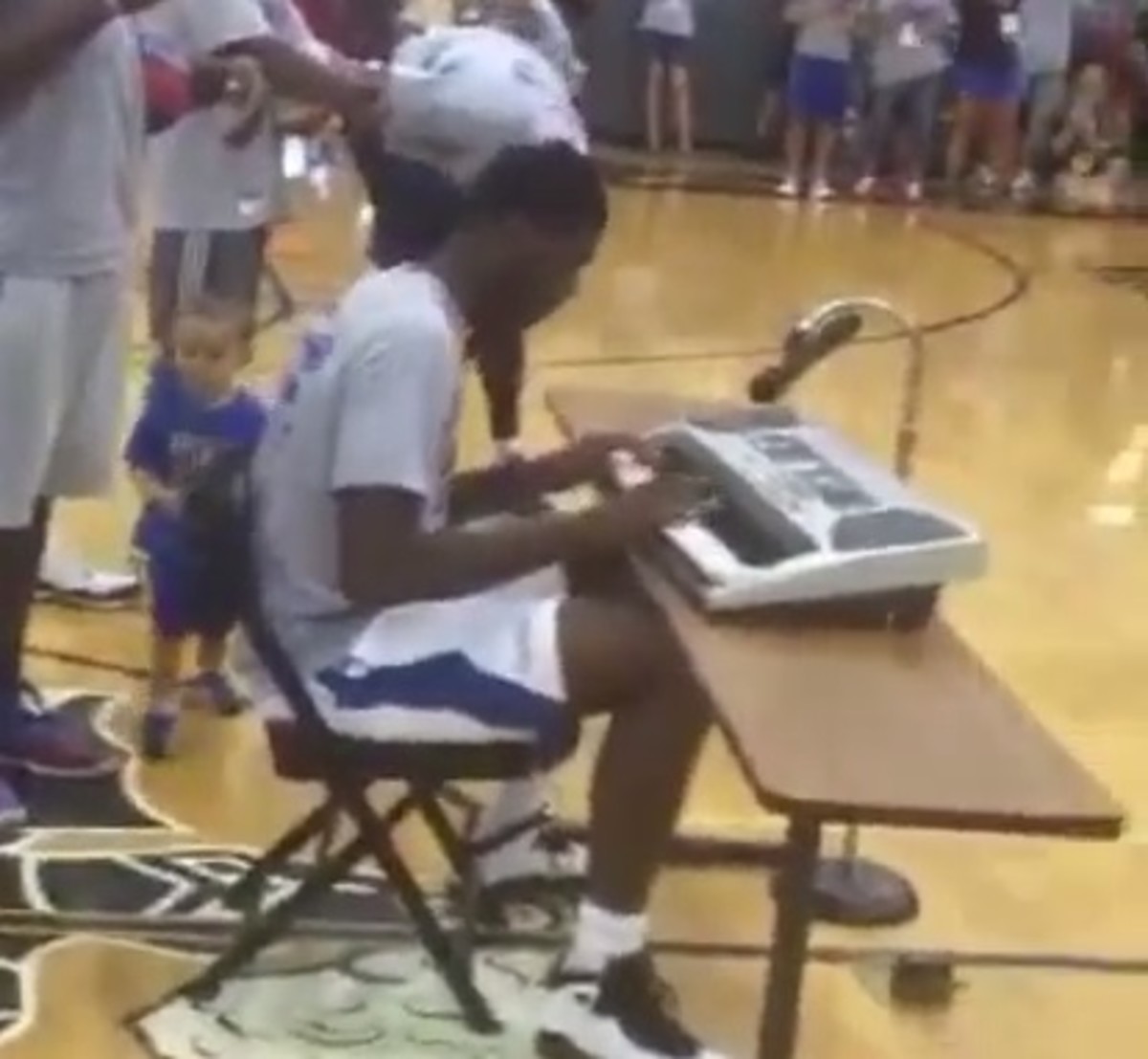 Kansas basketball player Carlton Bragg plays the piano for young basketball campers.