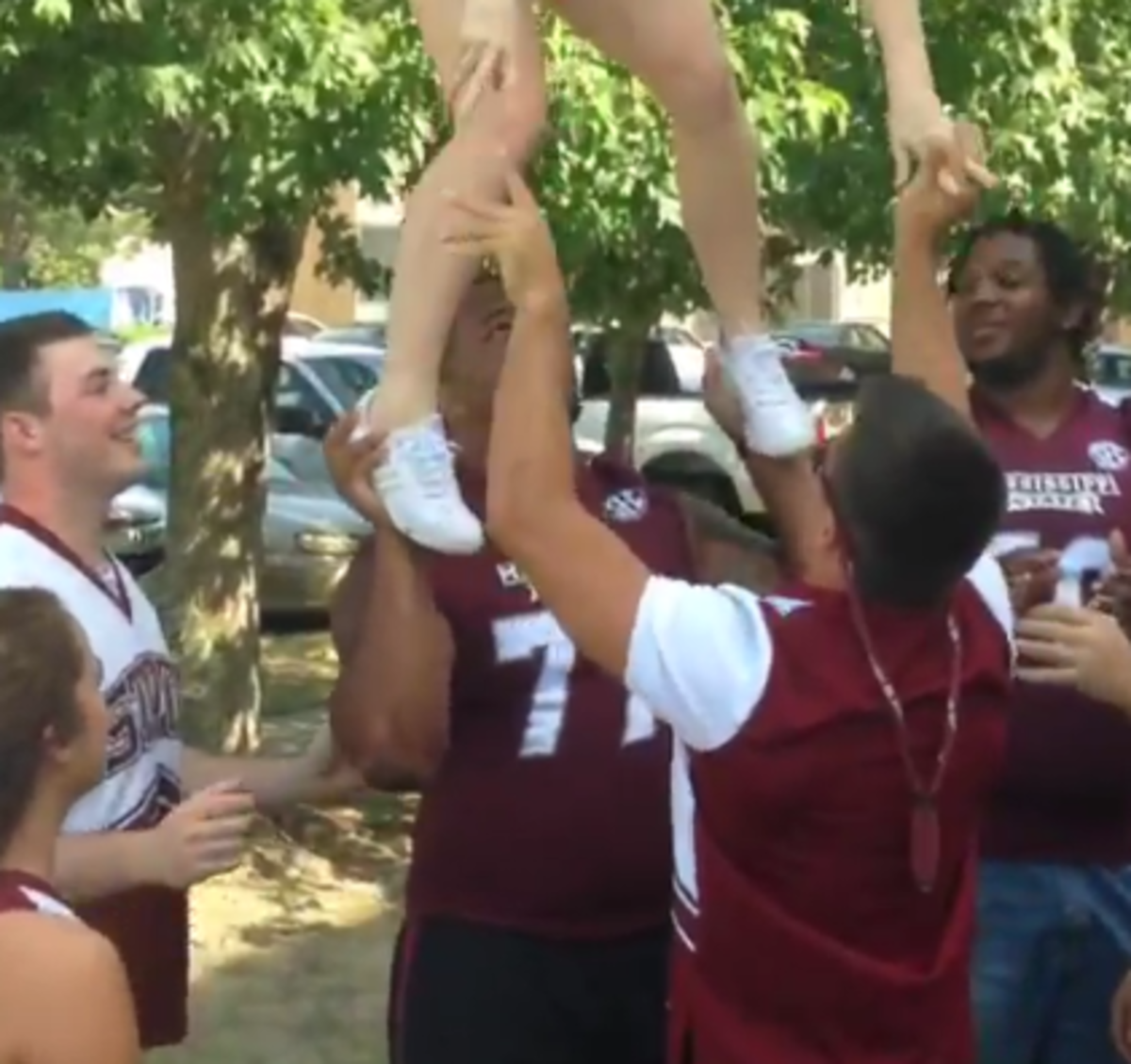 Mississippi State Offensive lineman attempts to hold an MS cheerleader.