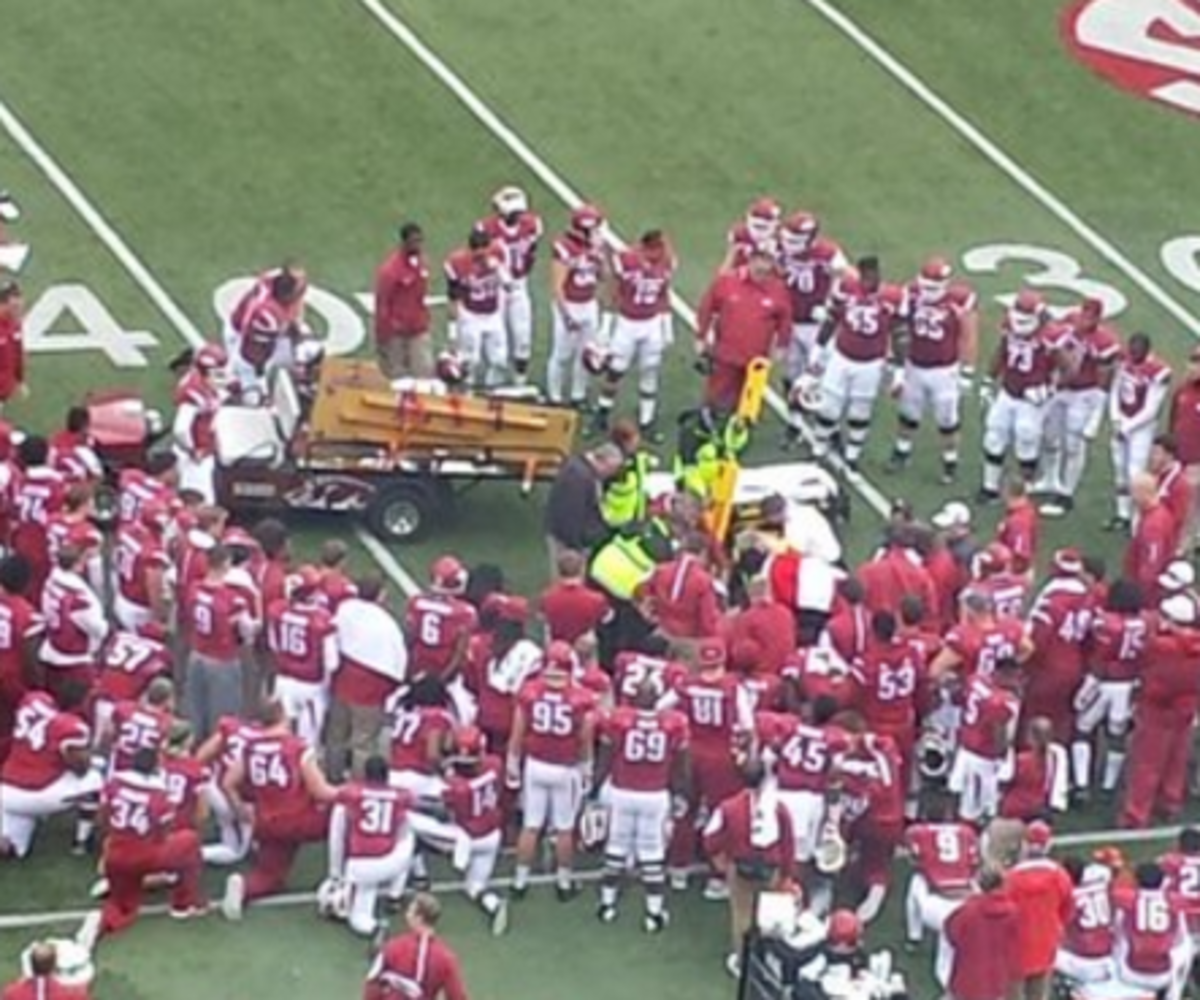 Arkansas freshman Rawleigh Williams surrounded by teammates before being carted off the field.