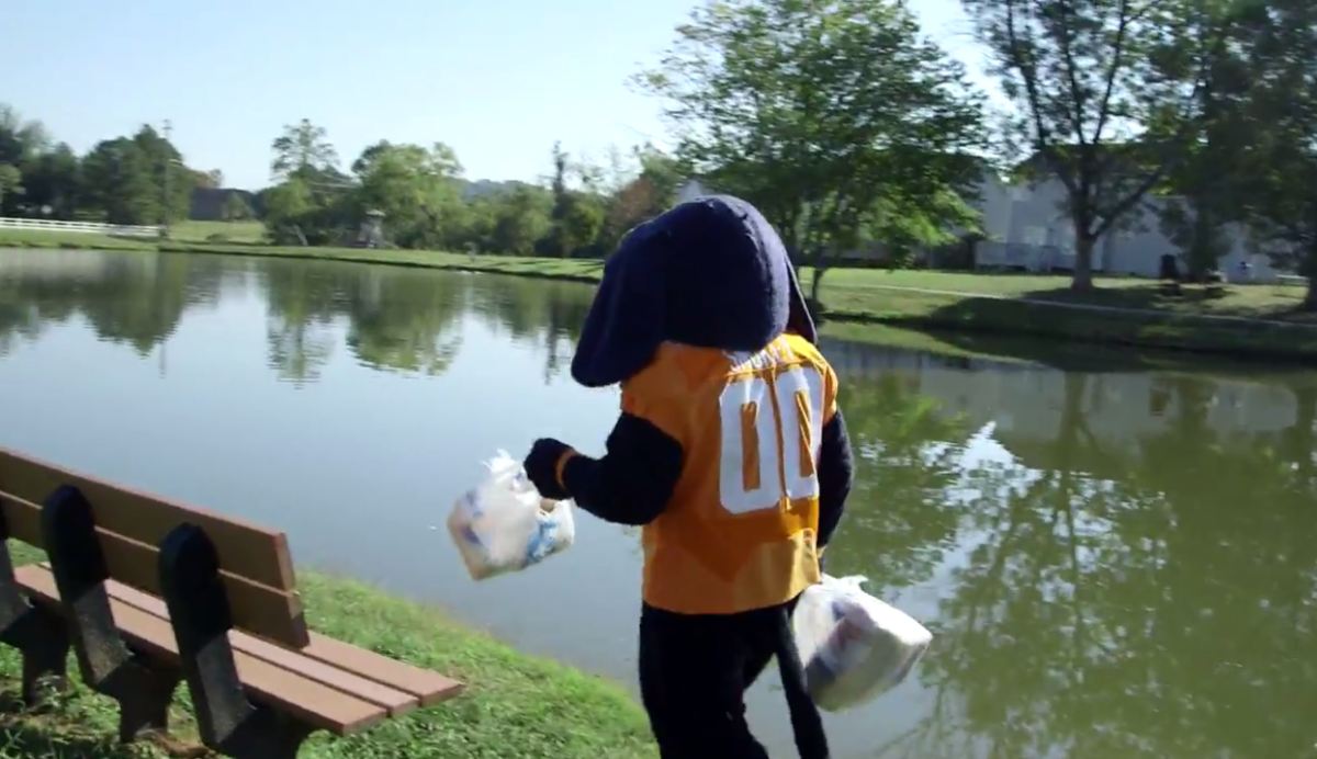 Tennessee's mascot walking by water with bigs in his hands.