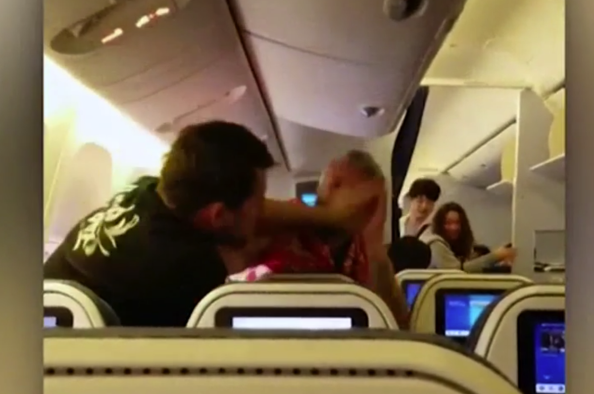 Two people fighting on an airplane.