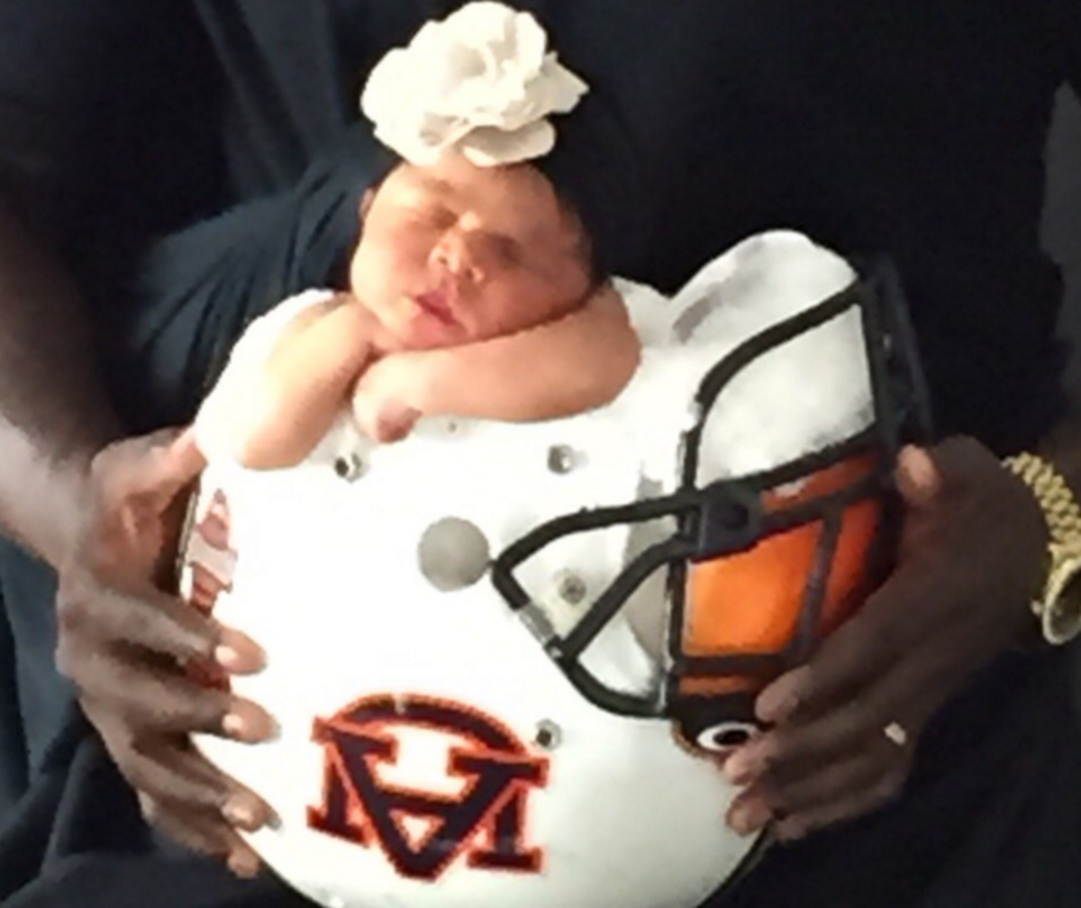 Ronnie Brown's newborn daughter in his Auburn football helmet.