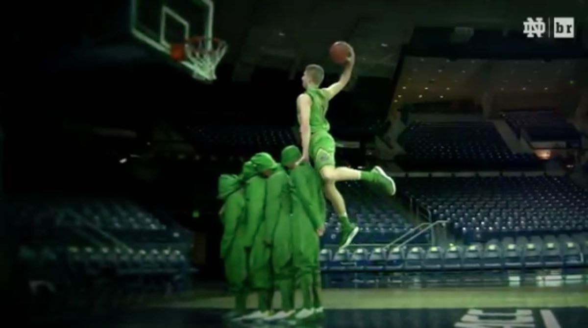 A Notre Dame basketball player dunks over four people.