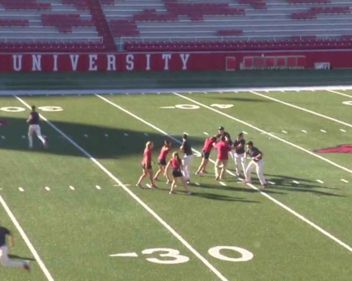 Arkansas golf team reenacts football teams 4th and 25 play on the football field.