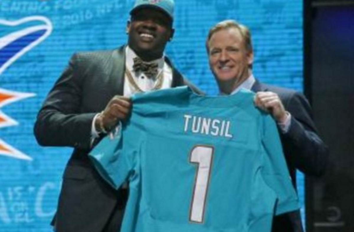 Laremy Tunsil and Goodell smile holding his draft jersey.