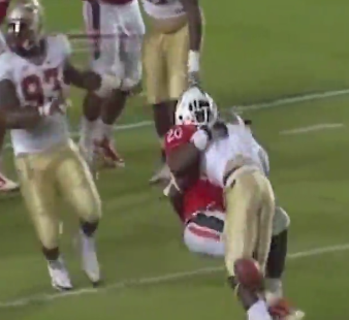 FSU player tackles a Miami ball carrier.