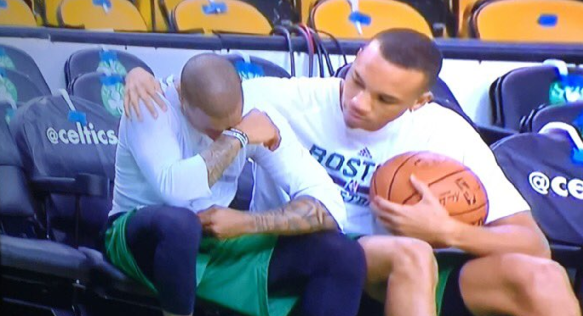 Isiah Thomas cries before the game next to teammate Avery Bradley on the bench.