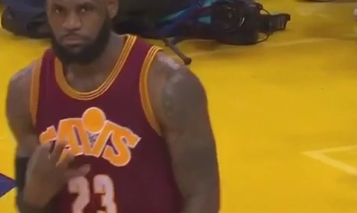 LeBron James throw up three fingers to his hecklers.