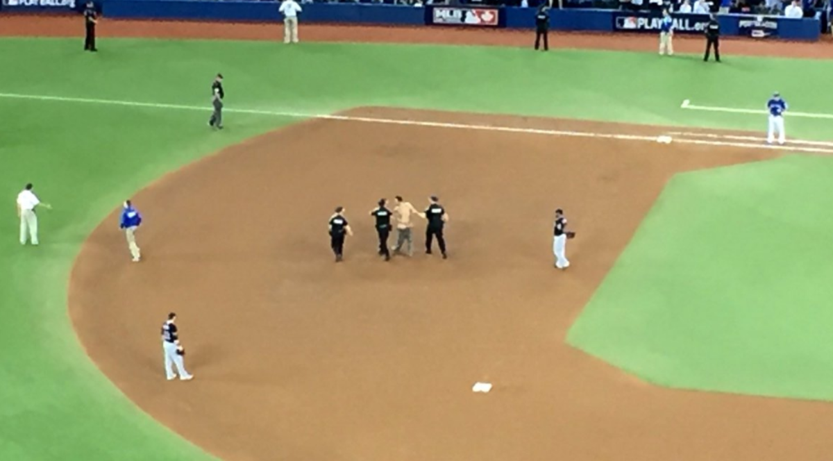 Security guards detaining a fan that ran onto the field