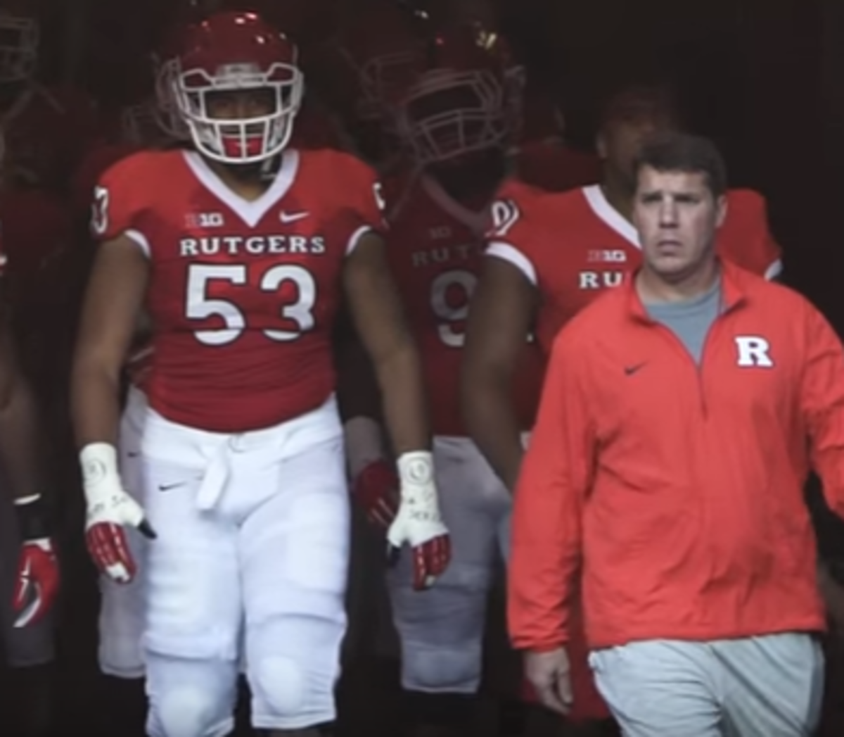Rutgers players walk out of tunnel onto field.