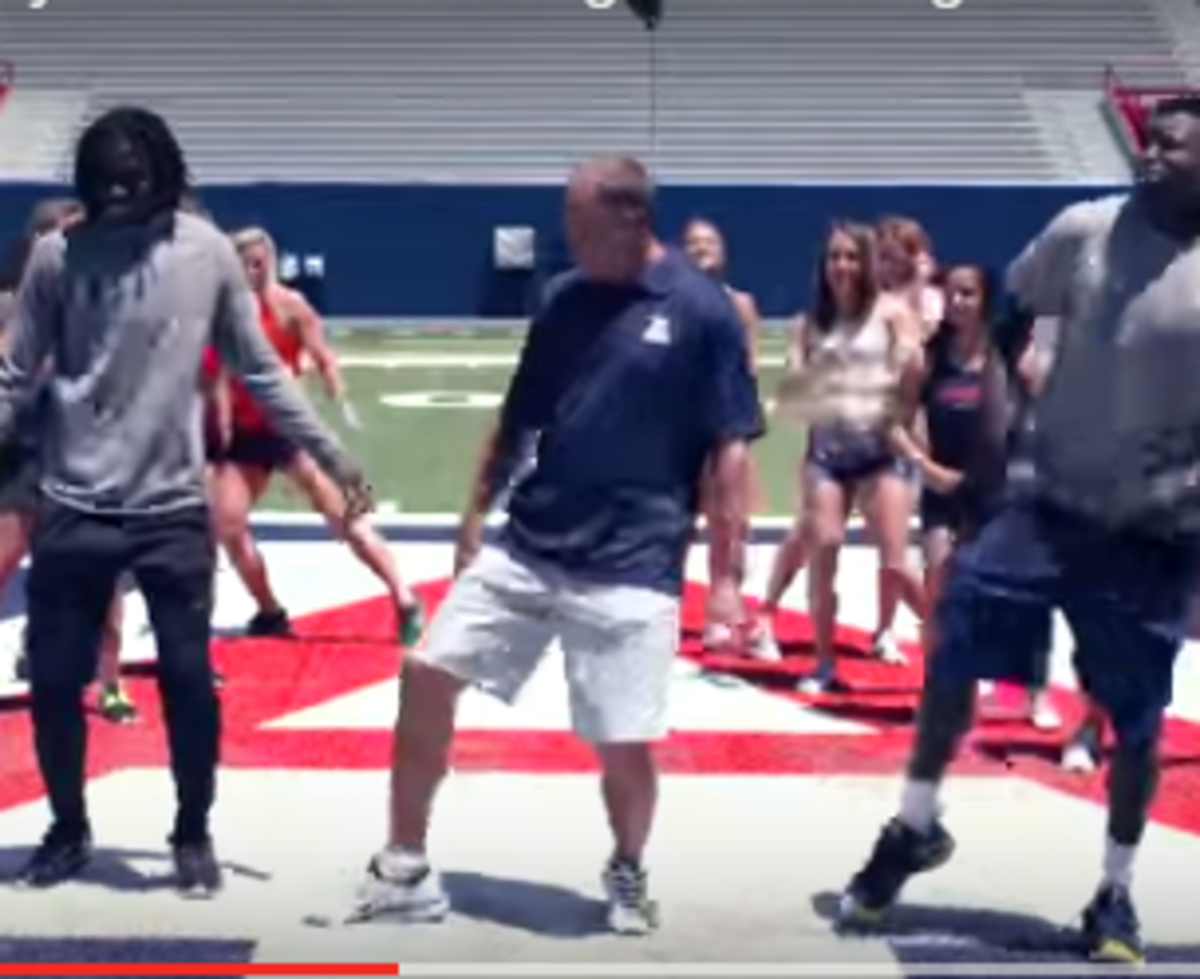 Arizona's Rich Rodriguez dances with his players.