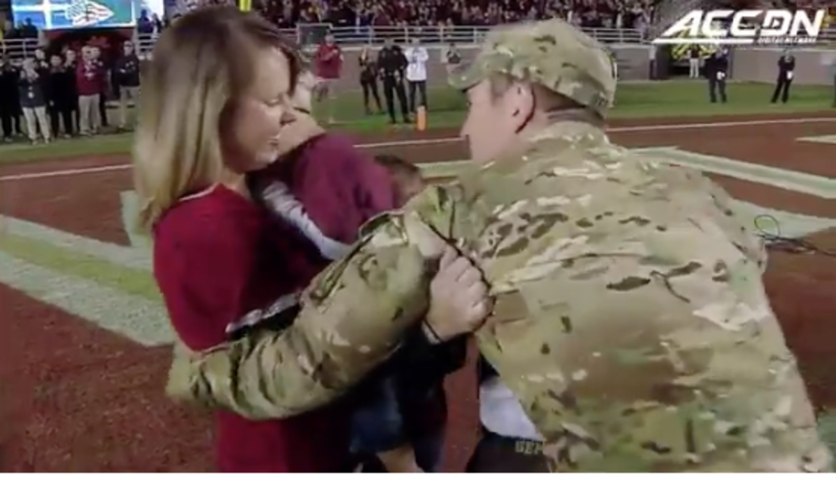 A solider surprises his wife at a Florida State game.