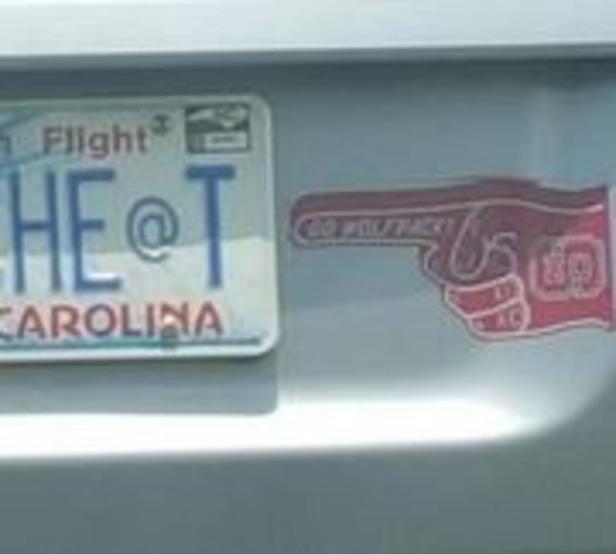 NC Stae finger bumper sticker pointing at a UNC cheats license plate.