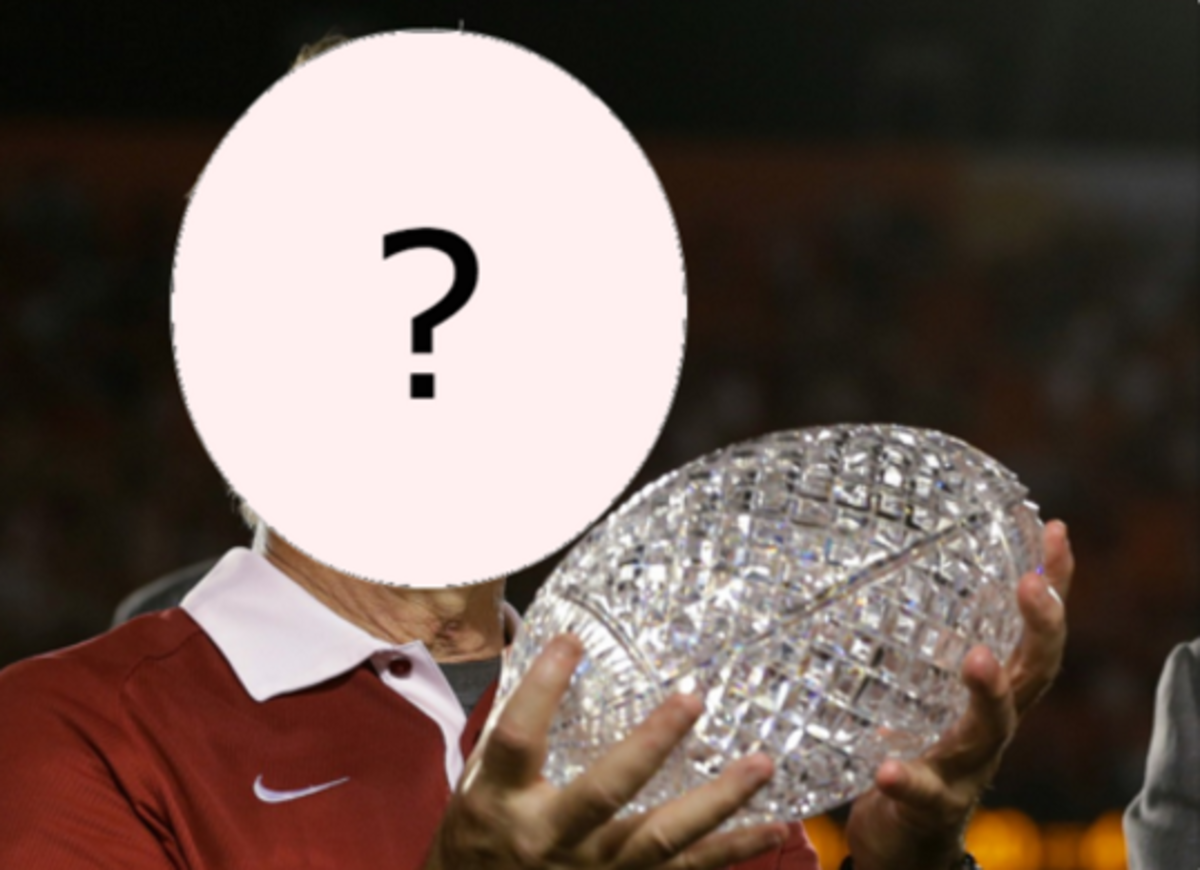 A CFB coach seen with his face covered.