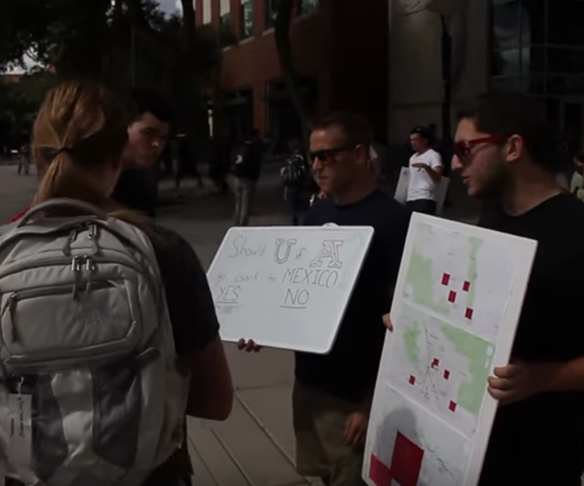 Arizona students hold up posters for their prank on ASU students.