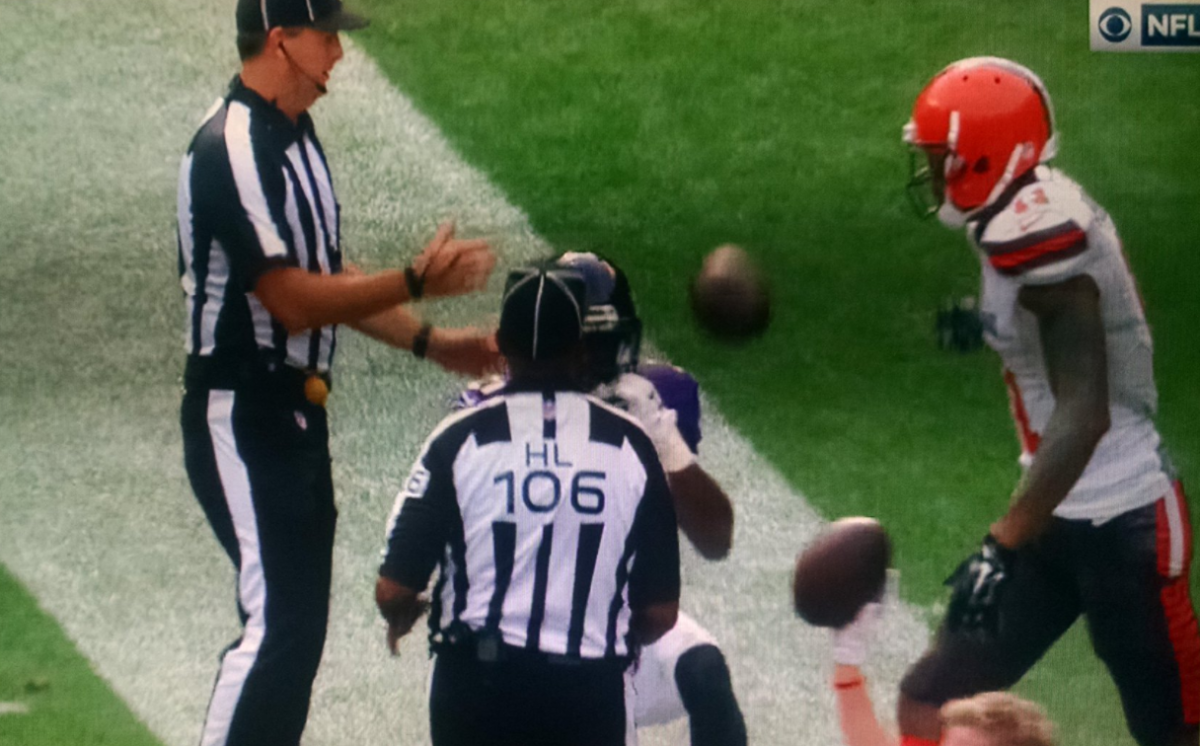 A picture of Terrelle Pryor handing the ball back to a ref.