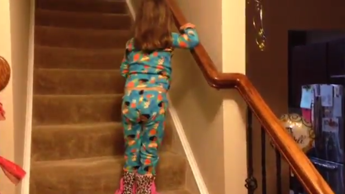 A girl with cancer walks up the stairs.