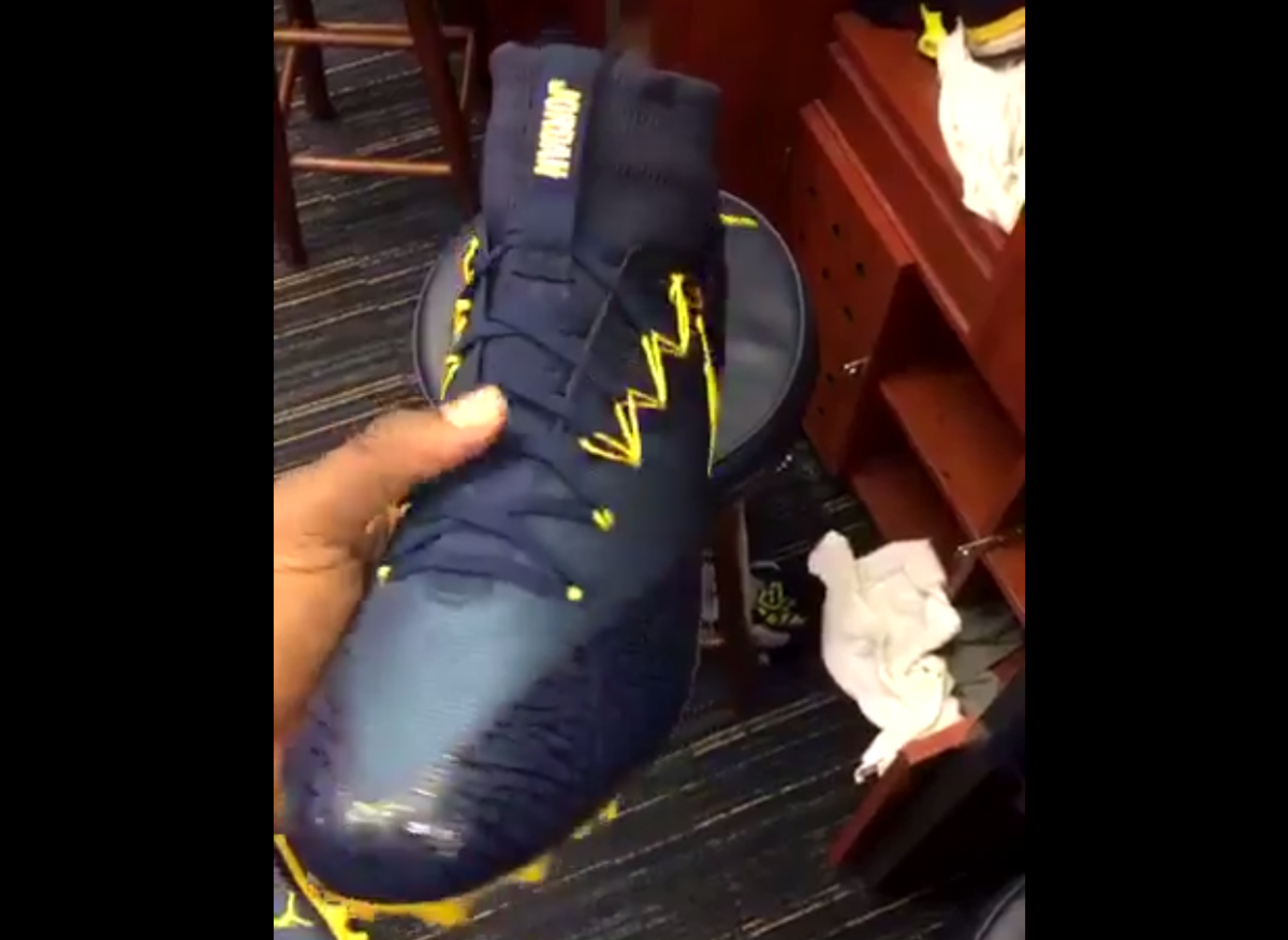 A Michigan player holding new Jordan Brand cleats.