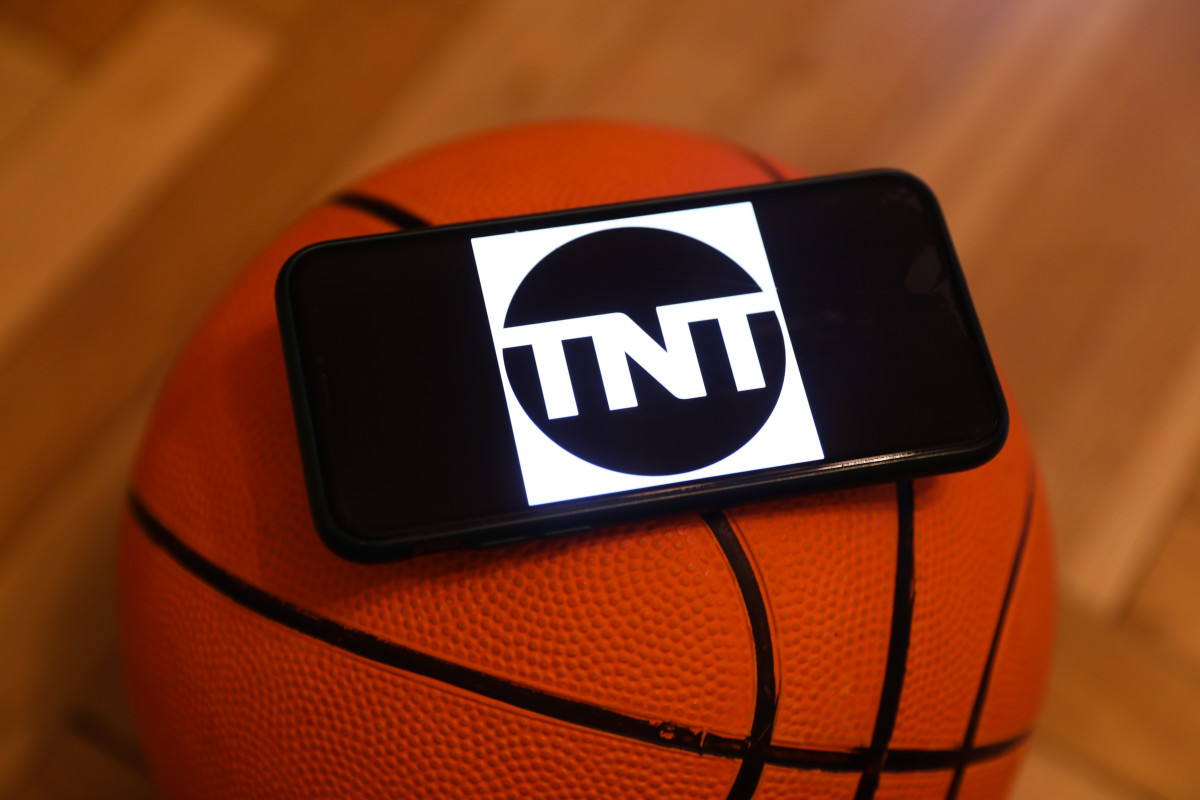 TNT logo displayed on a phone screen and a basketball are seen in this illustration photo taken in Krakow, Poland on December 1, 2022. (Photo by Jakub Porzycki/NurPhoto via Getty Images)