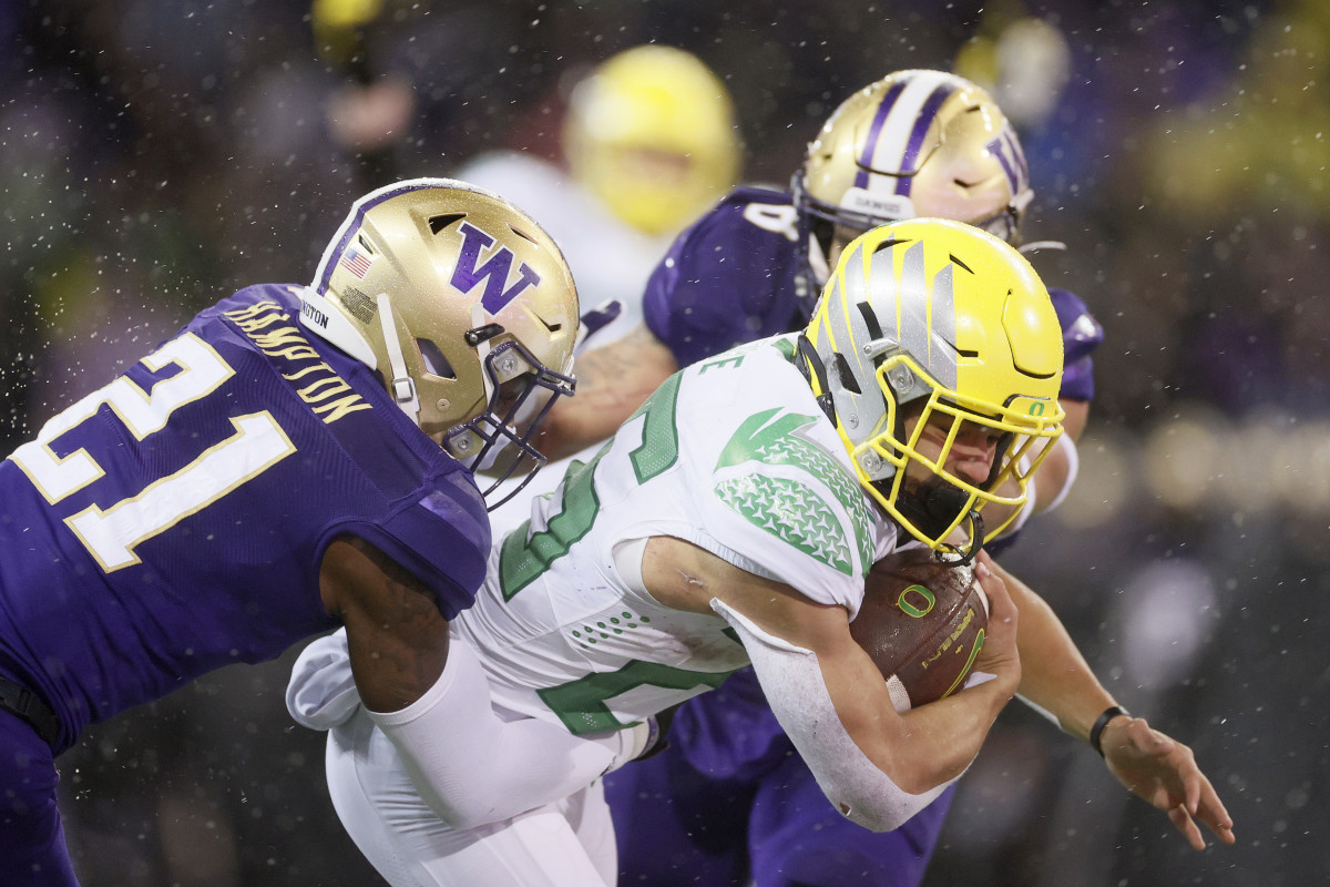 SEATTLE, WASHINGTON - NOVEMBER 06: Travis Dye #26 of the Oregon Ducks carries the ball against the Washington Huskies during the fourth quarter at Husky Stadium on November 06, 2021 in Seattle, Washington. (Photo by Steph Chambers/Getty Images)