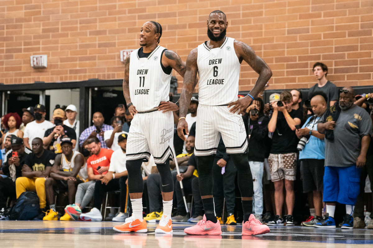 LOS ANGELES, CALIFORNIA - JULY 16: DeMar DeRozan and LeBron James smile on the court during the Drew League Pro-Am on July 16, 2022 in Los Angeles, California. (Photo by Cassy Athena/Getty Images)