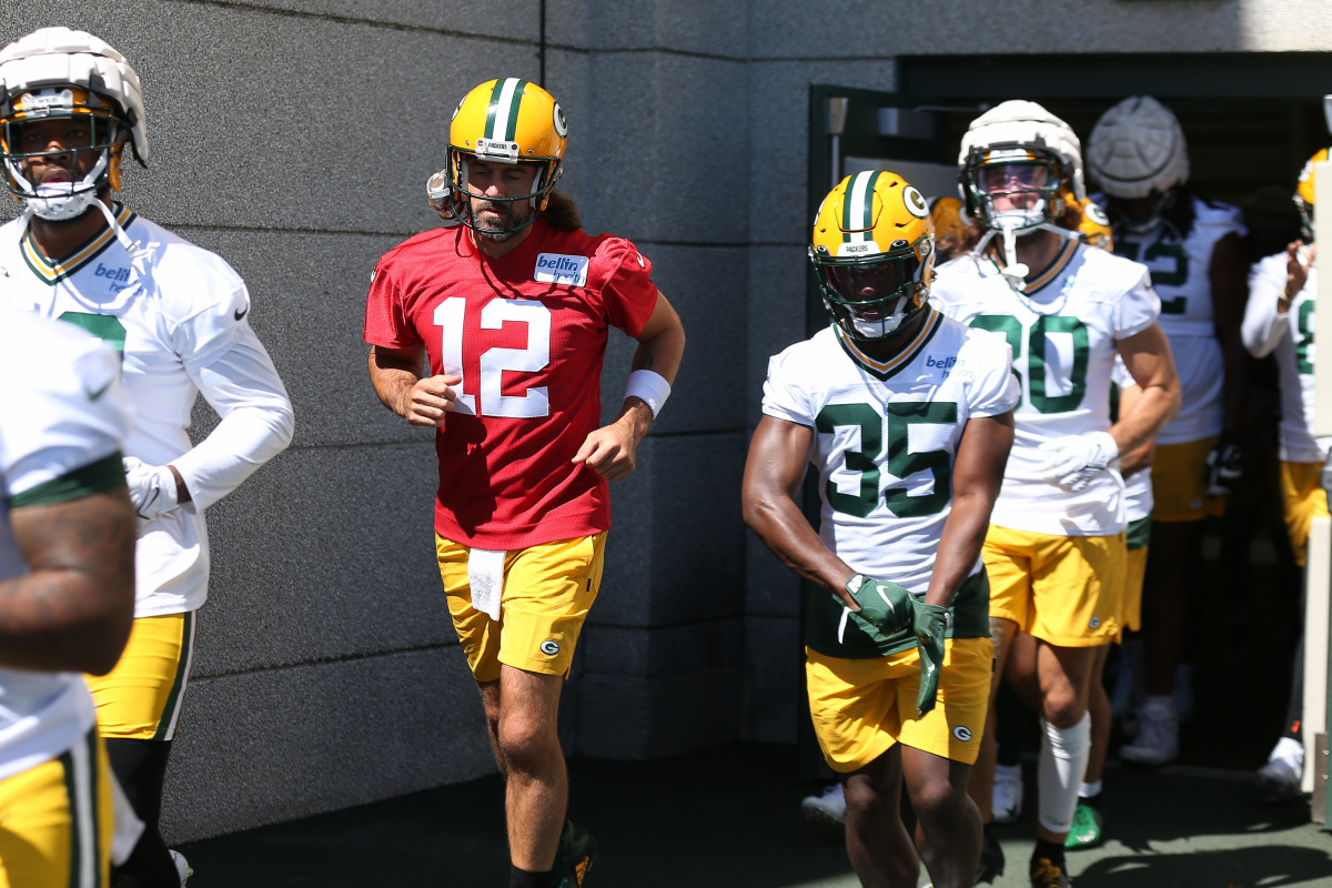 Aaron Rodgers runs onto the field before a training camp practice.
