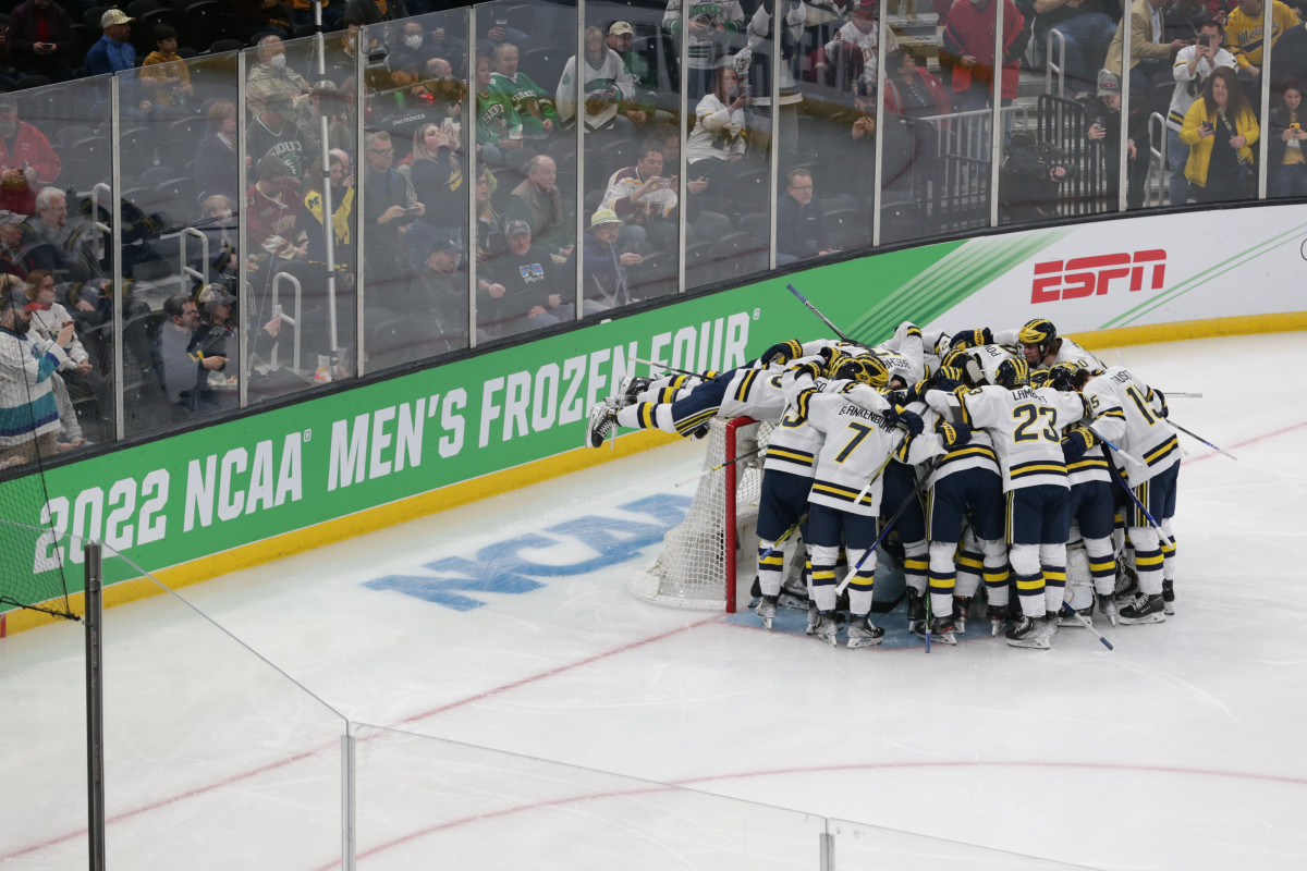 Michigan hockey players huddle in front of the net before a Frozen Four game.