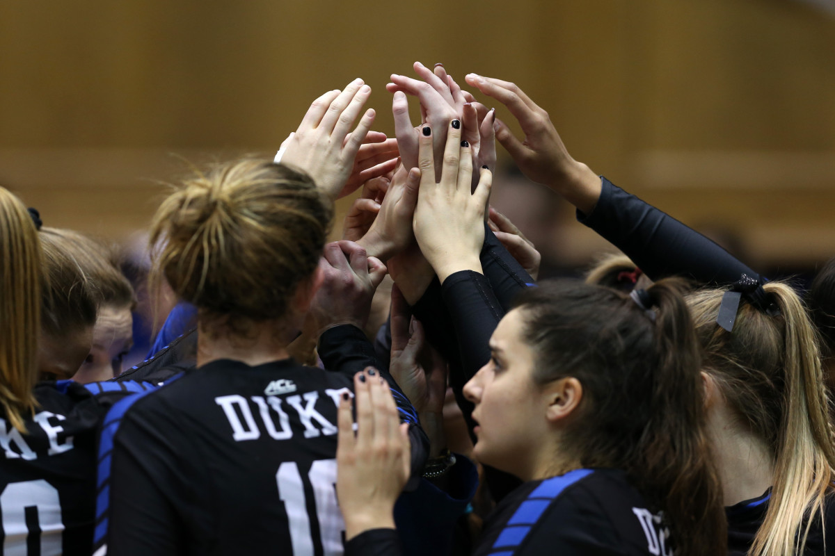 Duke volleyball players on the court before a game.