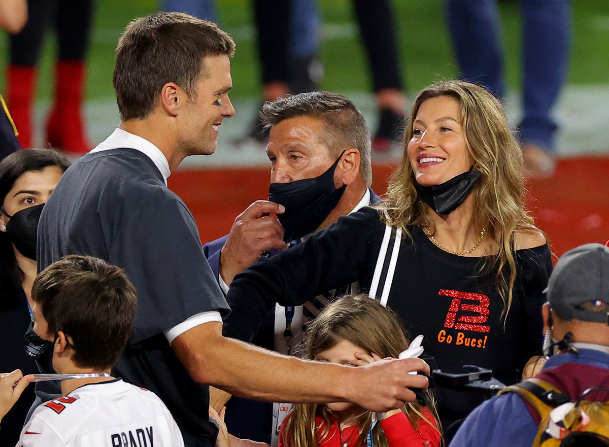 Tom Brady and his wife, Gisele, celebrating on the field at the Super Bowl.
